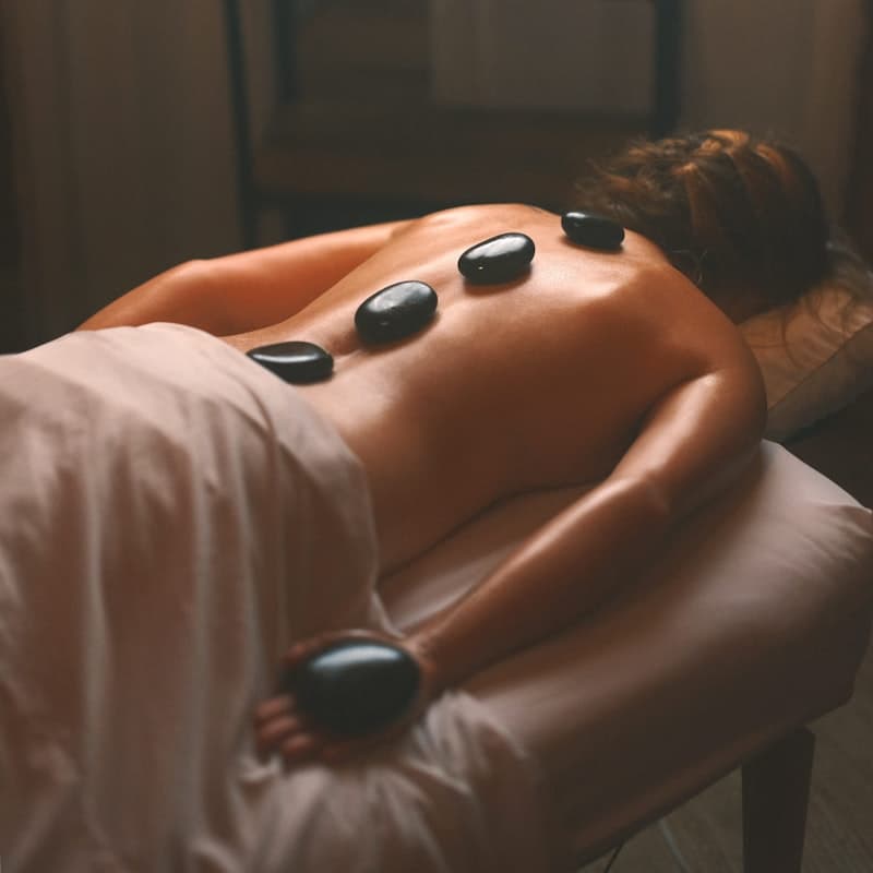 Hot stone massage therapy with warm basalt stones on the back